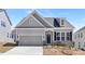 Charming single-Gathering home features a two-car garage, stone accents, and a welcoming front entrance with a wreath at 5096 Silver Creek Ln, Denver, NC 28037