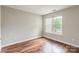 Cozy bedroom featuring laminate flooring, neutral paint, and large window at 5832 Amity Springs Dr, Charlotte, NC 28212