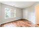 Bedroom features laminate flooring, neutral paint, large window, and closet space at 5832 Amity Springs Dr, Charlotte, NC 28212