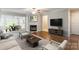 Bright living room featuring a fireplace, hardwood floors, and comfortable seating near the open dining area at 5832 Amity Springs Dr, Charlotte, NC 28212