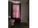 Small bathroom with a tub, toilet, maroon curtains, wood look flooring and limited natural light at 1926 Scenic Dr, Iron Station, NC 28080