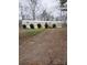 Cozy mobile home featuring a gravel driveway and small front yard landscaping with decorative bushes at 1926 Scenic Dr, Iron Station, NC 28080