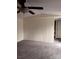 Open living room features neutral walls, a ceiling fan, neutral carpeting, and views of an interior door at 1926 Scenic Dr, Iron Station, NC 28080
