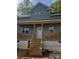 Charming home featuring a gray exterior, covered front porch, and a welcoming entrance with stairs and white door at 1506 7Th St, Statesville, NC 28677