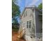 Attractive home showcasing light gray siding, double-hung windows, and a wooden staircase with access to a side door at 1506 7Th St, Statesville, NC 28677