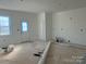 Bright living room featuring white walls, a door to the backyard, and building supplies at 1506 7Th St, Statesville, NC 28677