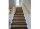 View of the home's staircase with wooden handrails, grey treads and white risers, offering access to the upper floors at 1506 7Th St, Statesville, NC 28677