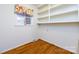 Small room with a window featuring a floral valance, built in shelving, and hardwood flooring at 5444 Marengo Cir, Charlotte, NC 28216