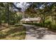 Long driveway leading to a charming brick home surrounded by lush trees providing a secluded feel at 5444 Marengo Cir, Charlotte, NC 28216