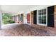 Inviting brick front porch with mosaic tiles, black shutters, and a bright red front door at 5444 Marengo Cir, Charlotte, NC 28216