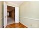 Hallway with hardwood floors leading to a carpeted room providing a comfortable living space at 5444 Marengo Cir, Charlotte, NC 28216