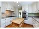 Well-equipped kitchen with stainless steel double ovens, white cabinets, and wood island at 5444 Marengo Cir, Charlotte, NC 28216