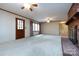 Open living room featuring a brick fireplace, neutral carpeting, and plentiful natural light from the large windows at 5444 Marengo Cir, Charlotte, NC 28216