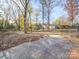 Spacious backyard featuring a stone patio area, mature trees, and privacy fence at 909 Woodhurst Dr, Monroe, NC 28110