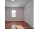 Bright bedroom with a large window and closet, showcasing the hardwood floors at 909 Woodhurst Dr, Monroe, NC 28110