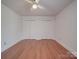 A bedroom with a ceiling fan and a double closet featuring hardwood floors and natural light at 909 Woodhurst Dr, Monroe, NC 28110