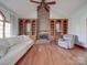 This living room includes a brick fireplace, hardwood floors, built-in bookcases, and soft lighting at 909 Woodhurst Dr, Monroe, NC 28110