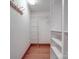 A walk-in closet featuring white shelving and wooden flooring with wall mounted coat hooks at 909 Woodhurst Dr, Monroe, NC 28110