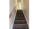 Carpeted stairs with neutral colored walls and natural wood railing at 1067 19Th Ne St # B, Hickory, NC 28601