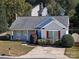 Single-story house shows a manicured lawn, colorful landscaping, and cracked concrete driveway at 14301 Beryl Ct, Pineville, NC 28134