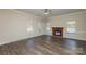 Open living space with wood floors, a cozy fireplace, and plenty of natural light from multiple windows at 14301 Beryl Ct, Pineville, NC 28134