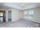 This bright main bedroom features a tray ceiling with a ceiling fan and two large windows at 14301 Beryl Ct, Pineville, NC 28134