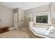 Bright bathroom featuring tiled shower with glass door and separate tub near window at 9723 Sedgefield Dr, Waxhaw, NC 28173