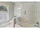 Bright bathroom featuring glass enclosed shower and bathtub combination and window at 9723 Sedgefield Dr, Waxhaw, NC 28173