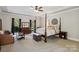 Cozy bedroom with a four-poster bed, tray ceilings, dresser, and natural light from the windows at 9723 Sedgefield Dr, Waxhaw, NC 28173