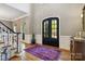 Grand foyer showcasing hardwood floors, wainscoting, and elegant black double doors at 9723 Sedgefield Dr, Waxhaw, NC 28173