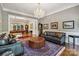 Elegant living room with hardwood floors, a decorative rug, a fireplace, and stylish seating at 9723 Sedgefield Dr, Waxhaw, NC 28173