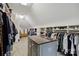 Large walk-in closet featuring custom shelves, drawers, and center island with granite countertop at 9723 Sedgefield Dr, Waxhaw, NC 28173