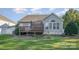 Backyard view showcasing a deck and a well-manicured lawn surrounded by mature trees and lush greenery at 1001 Hatton Ter, Fort Mill, SC 29707