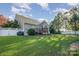 Lush backyard features a well-maintained lawn, mature trees, a deck, and a white picket fence for added privacy at 1001 Hatton Ter, Fort Mill, SC 29707