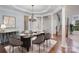 Elegant dining room featuring a chandelier, decorative columns, and a glass-topped table with seating for eight at 1001 Hatton Ter, Fort Mill, SC 29707