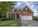 Beautiful brick home featuring a well-maintained lawn, mature landscaping, and a two-car attached garage at 1001 Hatton Ter, Fort Mill, SC 29707