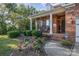 Inviting front porch with classic white columns, seating, and a beautifully landscaped front yard with vibrant flowers at 1001 Hatton Ter, Fort Mill, SC 29707