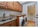 Practical laundry room with granite countertops, wooden cabinets, stainless steel sink, and modern washer/dryer appliances at 1001 Hatton Ter, Fort Mill, SC 29707