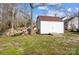 White shed with a ramp, surrounded by trees and firewood at 1509 Cripple Creek Rd, Kannapolis, NC 28081