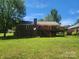 The backyard of the home, featuring a brick exterior and a wooden deck with access to a grassy lawn at 2015 Pine Needle Ct, Gastonia, NC 28056