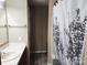 Neutral toned bathroom with a single sink vanity and a shower/tub combo with decorative curtain at 2015 Pine Needle Ct, Gastonia, NC 28056