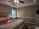Neutral bedroom featuring a tray ceiling, ceiling fan, and wood flooring at 2015 Pine Needle Ct, Gastonia, NC 28056