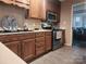 Kitchen featuring wood cabinetry and stainless steel appliances, plus a view into another room at 2015 Pine Needle Ct, Gastonia, NC 28056