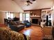 Inviting living room with a brick fireplace, hardwood floors, and an adjacent dining area at 2015 Pine Needle Ct, Gastonia, NC 28056