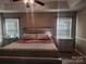 Main bedroom with tray ceiling, two windows, and a bed centered between two nightstands at 2015 Pine Needle Ct, Gastonia, NC 28056