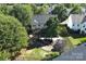 Aerial view of the backyard which has a pond, firepit, patio and manicured lawn at 3007 Gambrill Falls Dr, Indian Trail, NC 28079