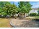 Landscaped backyard with stone patio, garden, fountain, and a covered porch at 3007 Gambrill Falls Dr, Indian Trail, NC 28079