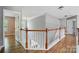 Spacious upstairs hallway with wood floors and white railings creates a bright and open feel at 3007 Gambrill Falls Dr, Indian Trail, NC 28079