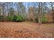 Wooded backyard with autumn leaves and a fence at 3216 High Ridge Rd, Charlotte, NC 28270