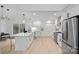 Modern white kitchen with stainless steel appliances and light wood floors at 3216 High Ridge Rd, Charlotte, NC 28270